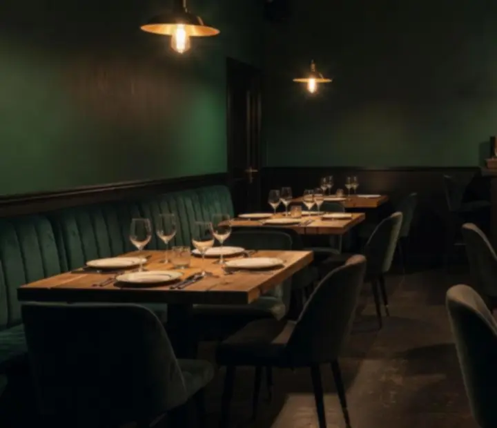 Gyertyafényes, hunter-zöld bistro lounge rendezvényhez megterített nyersfa asztalokkal